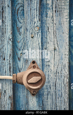Retro toned picture of an old switch on wooden wall, selective focus, color toning applied. Stock Photo