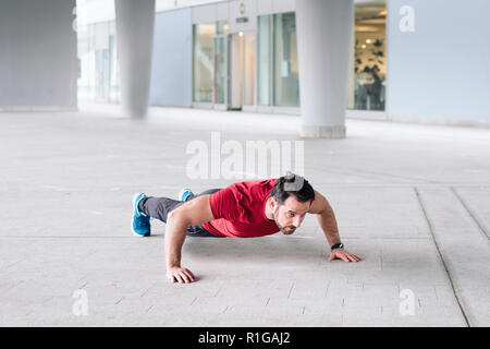 Urban sportsman doing push-ups reps exercise