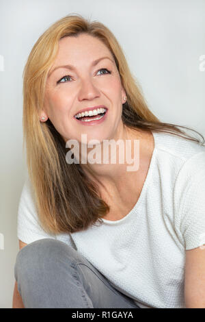 Studio portrait headshot of attractive happy middle aged blond woman in her forties Stock Photo