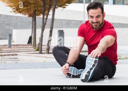Man with sportive clothes doing leg stretches exercises