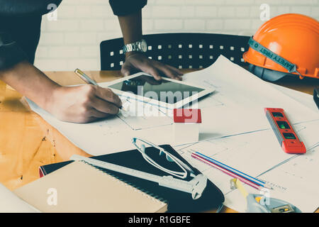 Architect or engineer using pen working on blueprint, architectural concept Stock Photo