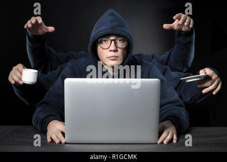 a programmer with six hands all a successful workaholic in the workplace Stock Photo