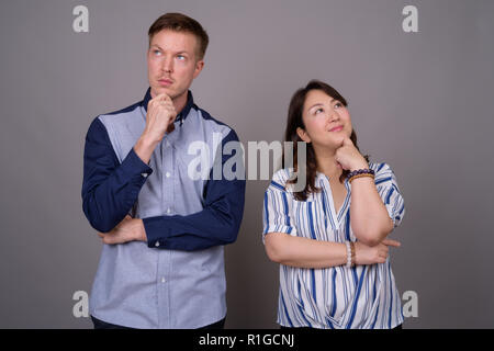 Portrait of multi ethnic diverse couple thinking Stock Photo