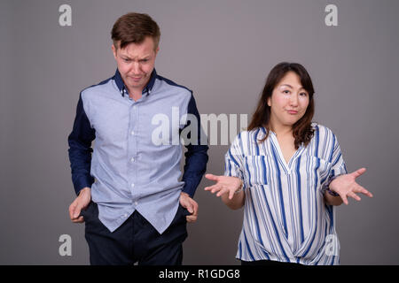 Portrait of multi ethnic diverse couple in studio with money problems Stock Photo