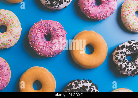 Top view of many colorful donuts on blue background. Stock Photo