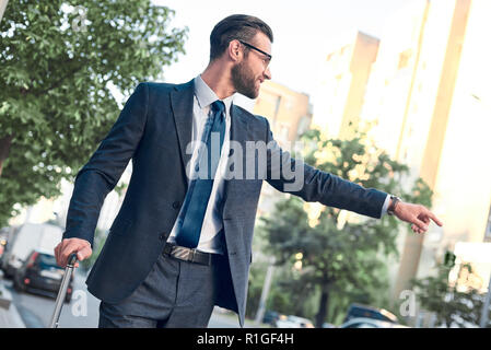Businessman trying to catch a taxi in business cuty district Stock Photo