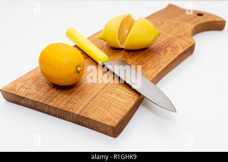 Sliced fresh lemon over chopping board.environmentally friendly, ecological products.prevention of colds.Sliced and whole lemons on cutting board with a knife .Copy space Stock Photo