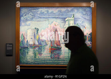Visitor in front of the painting 'Entrance of La Rochelle Harbor' ('Entrée du port de la Rochelle') by French Neo-Impressionist painter Paul Signac (1921) displayed in the Musée d'Orsay in Paris, France. Stock Photo