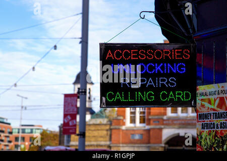 LED sign in front of a mobile phone repair shop advertising unlocking and repairs Stock Photo