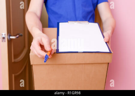 Image close up of courier with pen, blank sheet of paper, cardboard box Stock Photo