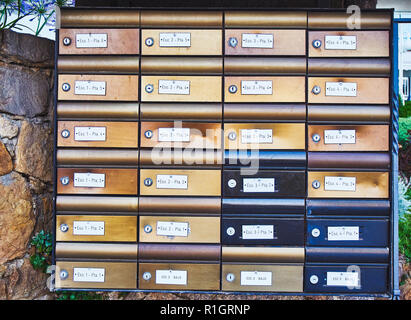 European aged metallic mailboxes on a stone wall. Stock Photo