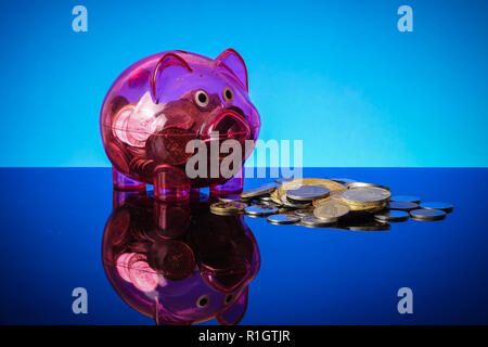 Saving concept with mason jar,coins and piggy bank on a blue background. Stock Photo