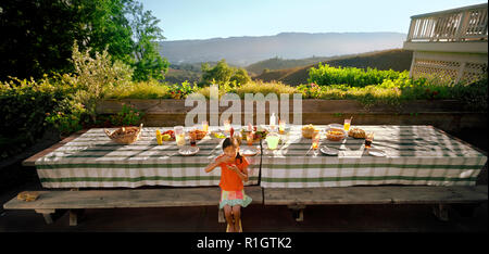 Young girl sneaking some food from the dining table. Stock Photo