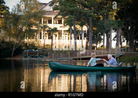 Happy senior couple holding hands while in a canoe. Stock Photo