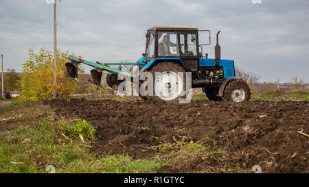 Agricultural work with tractors, plowing the land. Autumn work in the field. Stock Photo