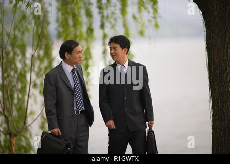 Two mid-adult businessmen having a discussion outdoors. Stock Photo