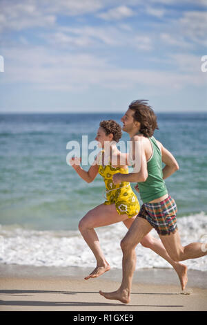 Young man and woman running next to each other on a beach.