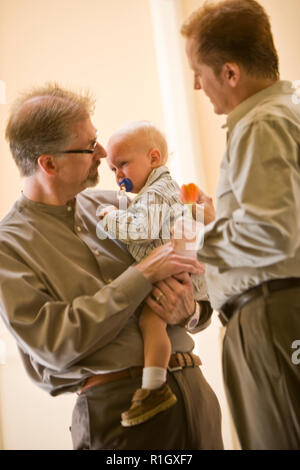 Two mid-adult men with a young toddler. Stock Photo