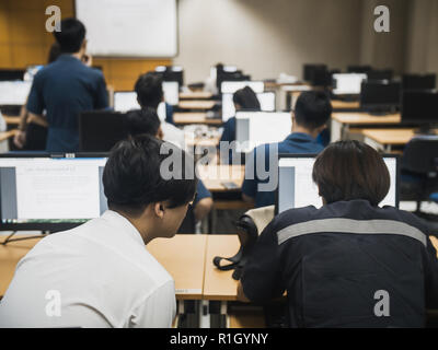 Samut Prakan, Thailand - November, 2018: Engineering students of Assumption University working in computer laboratory on their programming project Stock Photo