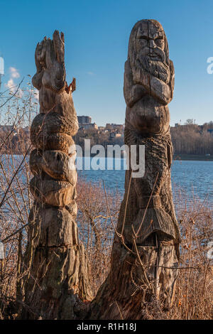 Wooden idols of the Slavic gods. Water in the background Stock Photo