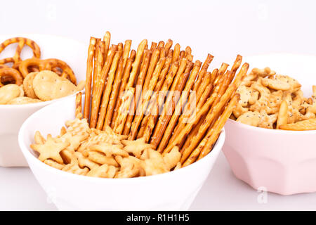 Different salted crackers in bowls on white background. Stock Photo