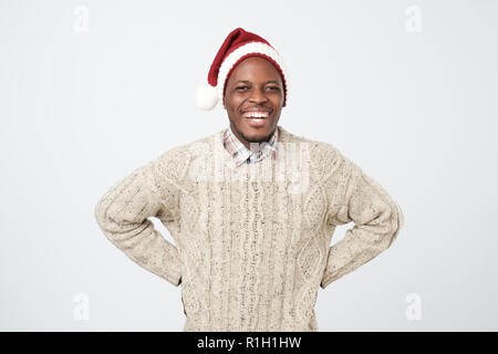 funny african man in christmas hat smiling and laughing. Happy new year concept. Stock Photo