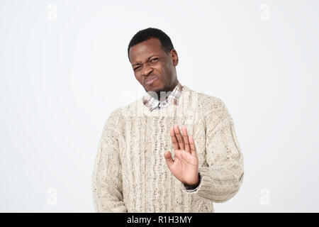 People and disagreement concept. African man makes stop gesture, rejects something. African American man refuses drink alcohol, show no sign Stock Photo