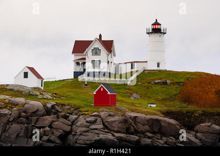 The red beacon of Nubble Light warns mariners of dangerous rocks and surf on the Atlantic Ocean East Coast Stock Photo