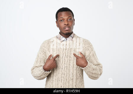 Young african man pointing at himself, making excuses or verbally defending, having perplexed and puzzled. Human face expressions, emotions and feelin Stock Photo