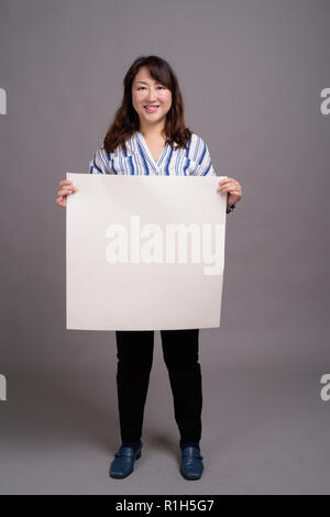 Japanese businesswoman holding white board with copyspace Stock Photo