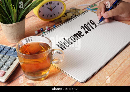 NEW YEAR CONCEPTUAL TEXT. Hand writing on notepad on a wooden table. Stock Photo