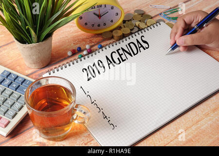 NEW YEAR CONCEPTUAL TEXT. Hand writing on notepad on a wooden table. Stock Photo