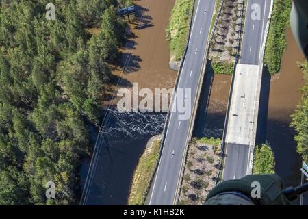 As seen from the air, the overflowing of the Cape Fear River is slowly joined by the darker, longer standing water from the surrounding areas outside of Elizabethtown, North Carolina on Sept. 19. Two UH-60 Blackhawk helicopters and 13 Soldiers assigned to a Lincoln-based Nebraska National Guard aviation unit support the ongoing Hurricane Florence relief operations from the Army Aviation Support Facility at the Raleigh International Airport in North Carolina. The Company G, 2-104th General Aviation Battalion Soldiers are equipped and trained to conduct search and rescue operations, as well as a Stock Photo