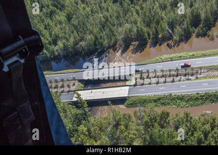 As seen from the air, the overflowing of the Cape Fear River is slowly joined by the darker, longer standing water from the surrounding areas outside of Elizabethtown, North Carolina on Sept. 19. Two UH-60 Blackhawk helicopters and 13 Soldiers assigned to a Lincoln-based Nebraska National Guard aviation unit support the ongoing Hurricane Florence relief operations from the Army Aviation Support Facility at the Raleigh International Airport in North Carolina. The Company G, 2-104th General Aviation Battalion Soldiers are equipped and trained to conduct search and rescue operations, as well as a Stock Photo