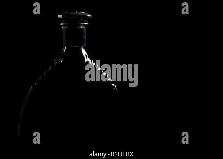 Silhouette Of Luxurious Alcohol Cognac Bottle Against Black Background Stock Photo