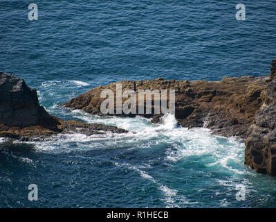 The sea breaks on a brown rock in the Atlantic on the coast of Ireland Stock Photo