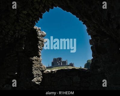 A wall opening with a view of the Rock of Cashel in sunshine Stock Photo