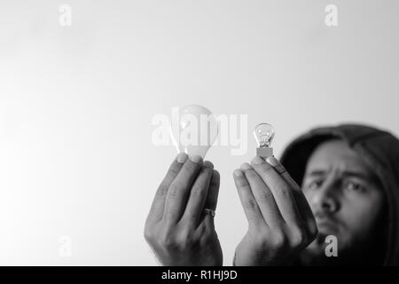 Engineer comparing two different light bulbs Stock Photo