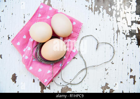 Top view of three eggs on rose napkin. Stock Photo