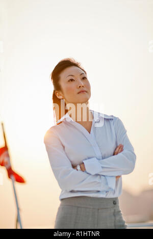 Thoughtful mid adult woman standing on a boat. Stock Photo