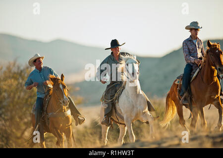 Guide leading a smiling family on a horseback ride. Stock Photo
