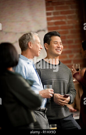 Colleagues enjoy having a drink and a casual chat after work. Stock Photo