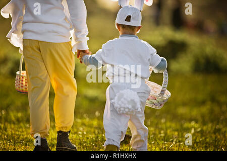 Two brothers in Easter costumes on an Easter egg hunt Stock Photo