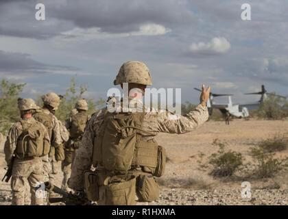 U.S. Marine Corps Staff Sgt. Corey Kolb with Alpha Company, 1st Battalion, 3d Marine Regiment, directs his Marines to board an MV-22B Osprey aircraft assigned to Marine Aviation Weapons and Tactics Squadron One (MAWTS-1) while conducting insertion operations in support of Weapons and Tactics Instructor (WTI) course 1-19 in Welton, Arizona, Sept. 19, 2018. WTI is a seven-week training event hosted by MAWTS-1 which emphasizes operational integration of the six functions of Marine Corps aviation in support of a Marine air-ground task force. WTI also provides standardized advanced tactical trainin Stock Photo