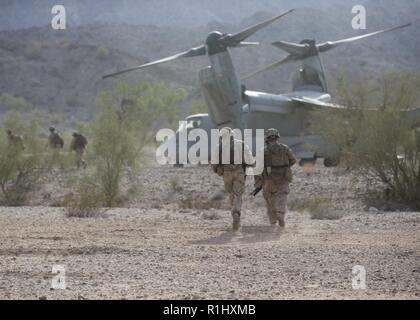 U.S. Marines with Alpha Company, 1st Battalion, 3d Marine Regiment, rush to board an MV-22B Osprey aircraft assigned to Marine Aviation Weapons and Tactics Squadron One (MAWTS-1) while conducting insertion operations in support of Weapons and Tactics Instructor (WTI) course 1-19 in Welton, Arizona, Sept. 19, 2018. WTI is a seven-week training event hosted by MAWTS-1 which emphasizes operational integration of the six functions of Marine Corps aviation in support of a Marine air-ground task force. WTI also provides standardized advanced tactical training and certification of unit instructor qua Stock Photo