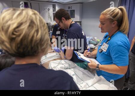 Carolinas MED 1 Mobile Hospital Unit provide medical care to a patient with a dislocated shoulder in Burgaw, NC, Sept. 22, 2018. Carolinas MED-1 deployed to the city of Burgaw in response to rising water levels from Hurricane Florence which blocked access to available hospitals in Wilmington, NC. Spc. Cory Long/CAISE Stock Photo