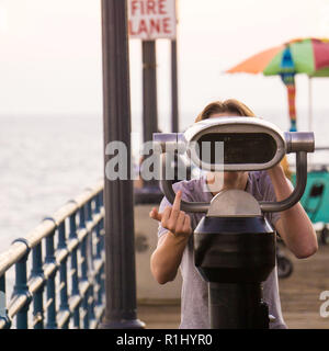 A cheeky boy with telescope at Santa Monica Pier Stock Photo