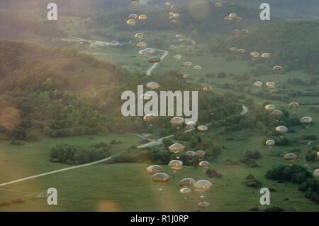 U.S. Army soldiers from the 173rd Airborne Brigade, as well as soldiers from various allied nations, parachute from U.S. Air Force C-130 aircraft onto a drop zone in Germany, Sept. 19, 2018. Saber Junction 18 is the U.S. Army 173rd Airborne Brigade’s combat training center certification exercise, taking place on the Grafenwoehr and Hohenfels training areas. The U.S. Army Europe-directed exercise is designed to assess the readiness of the brigade to conduct unified land operations in a joint, combined environment and to promote interoperability with participating allies and partner nations. Sab Stock Photo