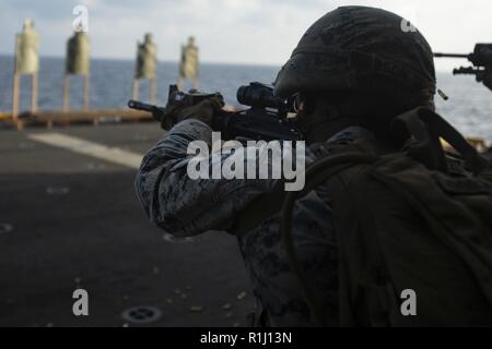Lance Cpl. Nayya Dobson El, a rifleman with Company F, Battalion Landing Team, 2nd Battalion, 5th Marines, fires an M4 carbine during marksmanship training aboard the amphibious assault ship USS Wasp (LHD 1), underway in the South China Sea, Sept. 25, 2018. Company F is the helicopter-borne raid element with BLT 2/5, the Ground Combat Element for the 31st Marine Expeditionary Unit. Dobson El, a native of Miami, Florida, graduated from North Miami Beach Senior High School in June 2016 and enlisted August 2016. The 31st MEU, the Marine Corps’ only continuously forward-deployed MEU, provides a fl Stock Photo