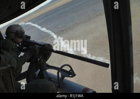 U.S. Marine Corps Cpl. Preston Eisele, a UH-1Y aircraft crew chief with Marine Light Attack Helicopter Squadron (HMLA) 469, Marine Aircraft Group 38, 3rd Marine Aircraft Wing, engages targets in support of Weapons and Tactics Instructor (WTI) course 1-19 in Yuma, Arizona, Sept. 20, 2018. WTI is a seven-week training event hosted by Marine Aviation Weapons and Tactics Squadron One (MAWTS-1) which emphasizes operational integration of the six functions of Marine Corps aviation in support of a Marine air-ground task force. WTI also provides standardized advanced tactical training and certificatio Stock Photo